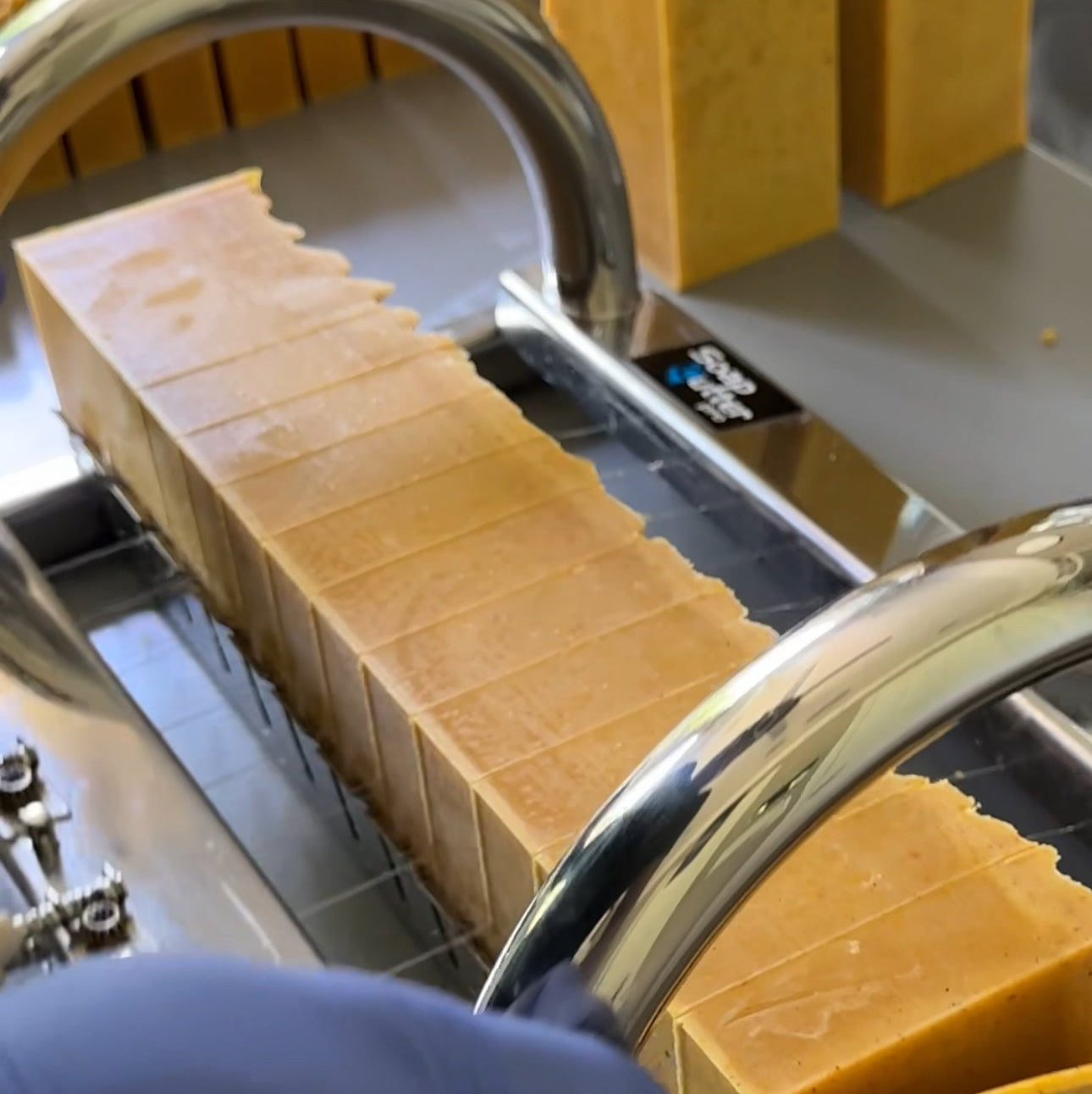 Soap log being cut into soap bars with a close-up view. Florida Sunshine citrus soap bar handcrafted with natural ingredients