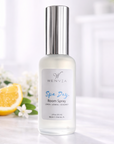 Room spray bottle with floral and citrus elements on a light background